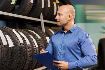 Image showing auto business owner and wheel tires at car service