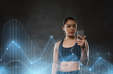 Image showing woman with smartphone and earphones in gym