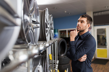 Image showing male customer choosing wheel rims at car service