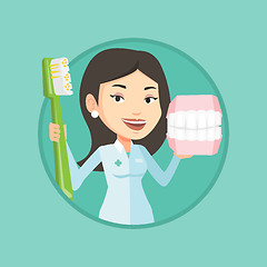 Image showing Dentist with dental jaw model and toothbrush.