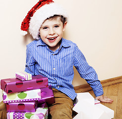 Image showing little cute boy with Christmas gifts at home. close up emotional