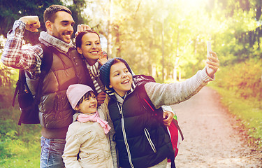 Image showing family with backpacks taking selfie by smartphone