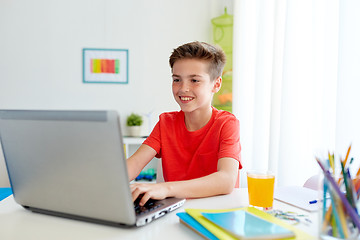 Image showing student boy typing on laptop computer at home