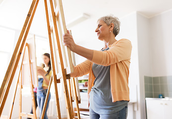 Image showing woman artist with easel drawing at art school