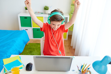 Image showing boy with headphones playing video game on laptop