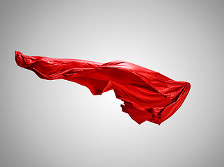 Image showing Smooth elegant transparent red cloth separated on gray background.