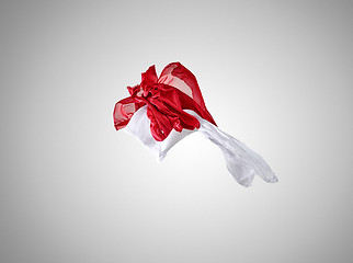 Image showing Smooth elegant transparent red and white cloth separated on gray background.