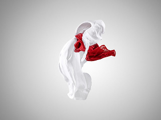 Image showing Smooth elegant transparent red and white cloth separated on gray background.