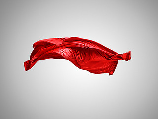 Image showing Smooth elegant transparent red cloth separated on gray background.