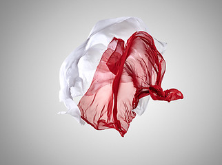 Image showing Smooth elegant transparent red and white cloth separated on gray background.