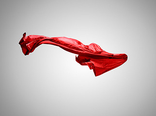 Image showing Smooth elegant transparent red cloth separated on gray background.