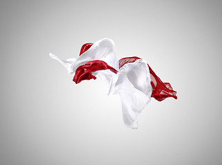 Image showing Smooth elegant transparent red and white cloth separated on gray background.