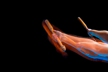 Image showing The arm with wooden baseball bat on black background