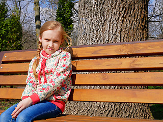 Image showing Small girl sits on the bench