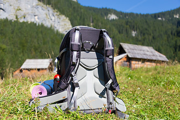 Image showing Backpack and yoga mats on mountain meadow.