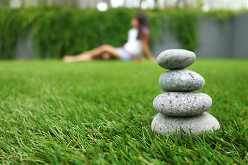 Image showing Pebbles stacked up on grass