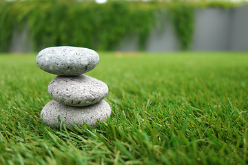 Image showing Pebbles stacked up on grass