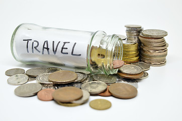 Image showing Travel lable in a glass jar with coins spilling out