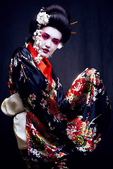 Image showing young pretty geisha in kimono with sakura and decoration