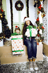 Image showing happy family on Christmas in red hats waiting gests and smiling outdoor