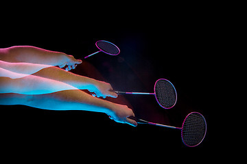 Image showing The hands of young man playing badminton over black background