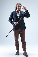 Image showing The mature barded man in a suit holding cane.