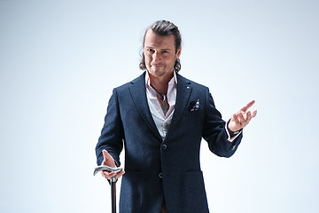 Image showing The mature barded man in a suit holding cane.