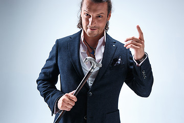 Image showing The mature barded man in a suit holding cane.