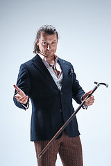 Image showing The mature barded man in a suit holding cane.