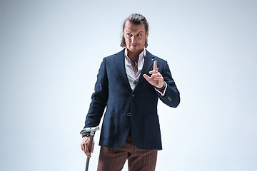 Image showing The mature barded man in a suit holding cane.