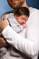 Image showing Portrait of young happy couple embracing to their newborn.