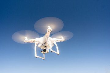 Image showing White Quadcopter Drone Flying Hoovering Blue Sky