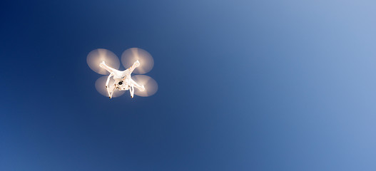 Image showing White Quadcopter Drone Flying Hoovering Blue Sky