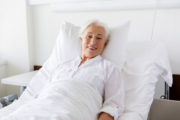 Image showing smiling senior woman lying on bed at hospital ward