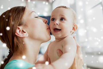 Image showing happy young mother kissing little baby at home