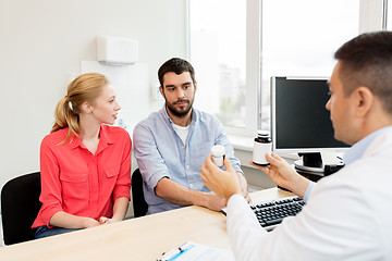 Image showing doctor showing medicine to family couple at clinic