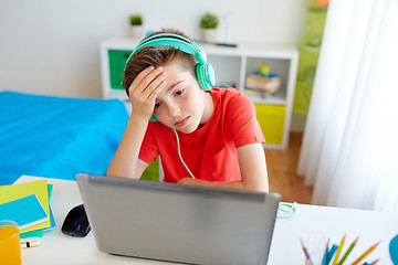 Image showing boy in headphones playing video game on laptop