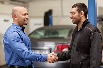 Image showing mechanic and customer shaking hands at car service