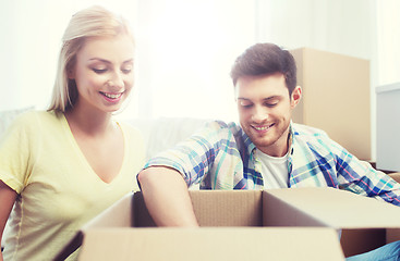 Image showing smiling couple with big boxes moving to new home