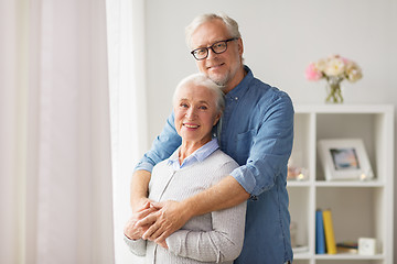 Image showing happy senior couple hugging at home