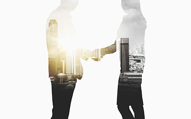 Image showing business people shaking hands over city background