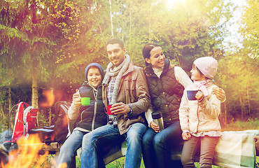 Image showing happy family drinking hot tea at camp fire