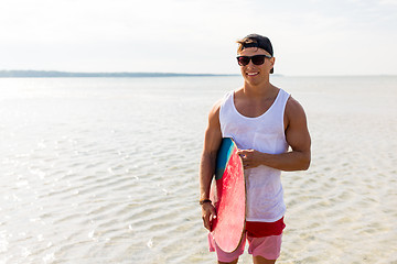 Image showing happy young man with skimboard on summer beach