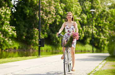 Image showing happy woman riding fixie bicycle in summer park