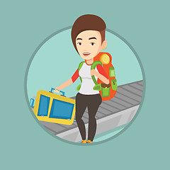 Image showing Woman picking up suitcase on luggage conveyor belt