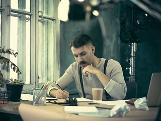 Image showing Architect working on drawing table in office