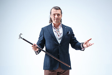 Image showing The mature barded man in a suit holding cane.