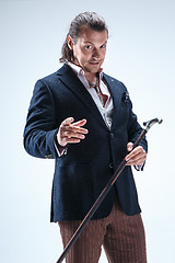 Image showing The mature barded man in a suit holding cane.