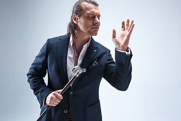 Image showing The mature barded man in a suit holding cane.