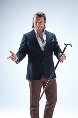 Image showing The mature barded man in a suit holding cane.